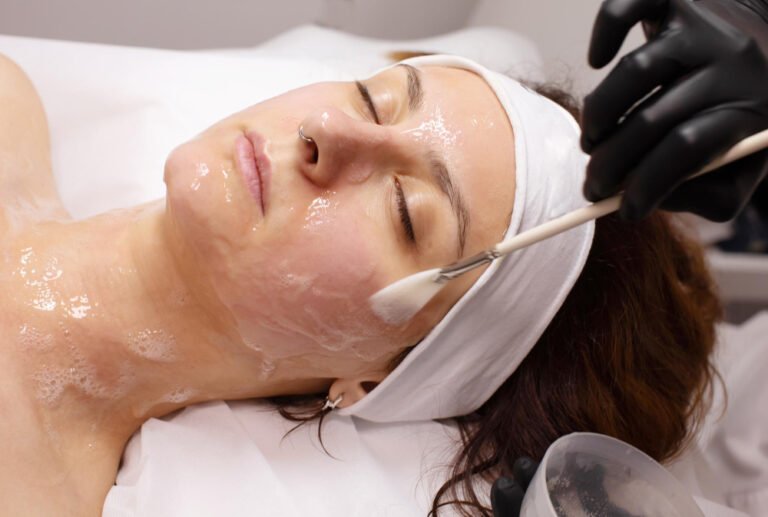 applying a white chemical peel serum to a client's face during a facial treatment