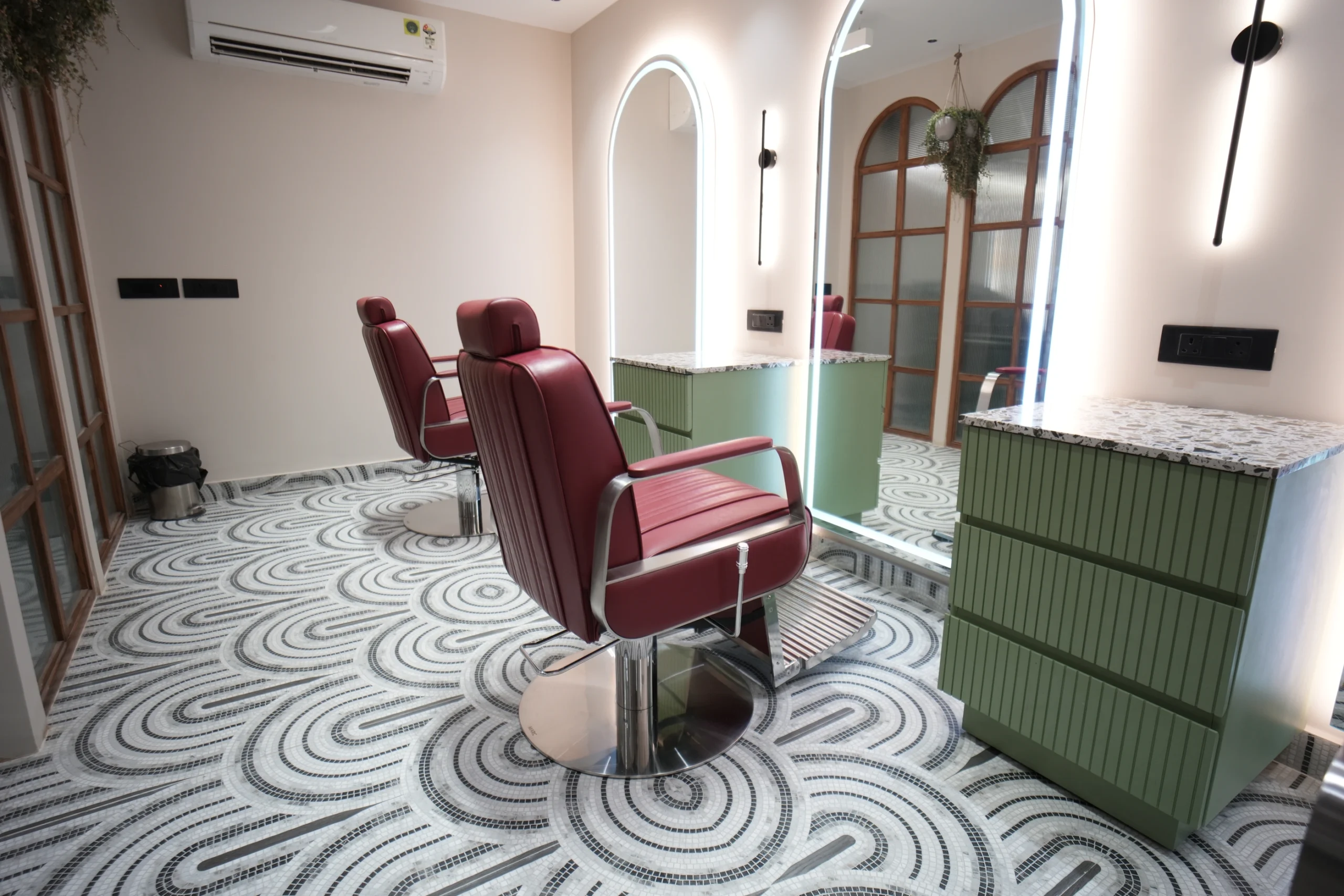Bellance Salon private styling room with burgundy leather chairs, arched lit mirrors, and mosaic swirl floor tiles