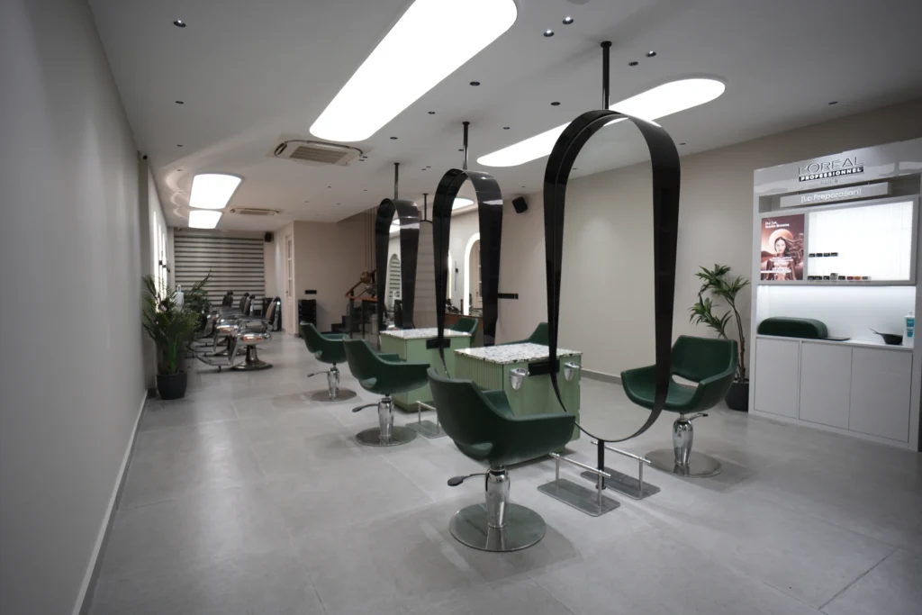 Bellance Salon interior with green styling chairs, oval pendant mirrors, and L'Oreal Professionnel product display